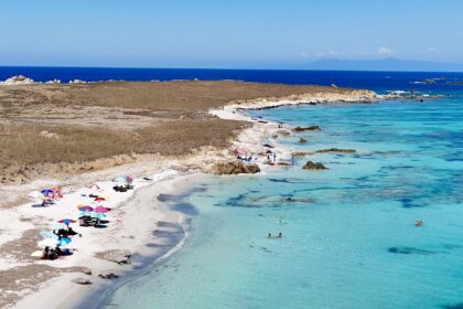 Spiaggia principale dell'Isola di Mal di Ventre vista dal drone, con ombrelloni sulla sabbia bianca e acqua turchese
